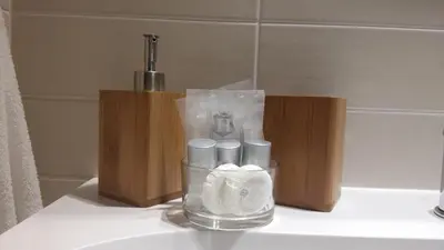 a glass vase with toiletries on a bathroom sink at Jubilee 2 in Rome
