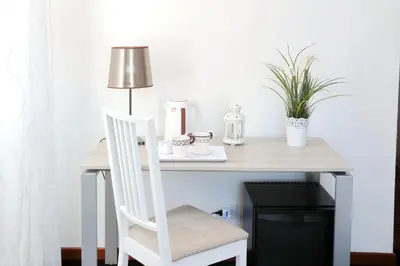 a desk with a chair and a table with a lamp at Relais Incantesimo Vaticano in Rome