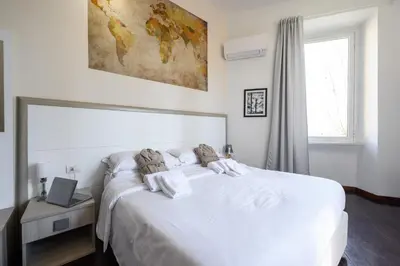 a bedroom with a white bed with a laptop on it at Relais Incantesimo Vaticano in Rome