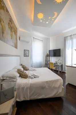 a bedroom with a large white bed and a desk at Relais Incantesimo Vaticano in Rome