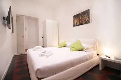 a white bed with green pillows in a room at Spanish Steps Art Apartment in Rome