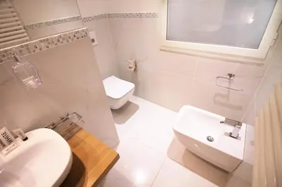 a white bathroom with a sink and a toilet at Spanish Steps Art Apartment in Rome