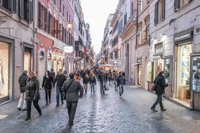 a group of people walking down a cobblestone street at Spanish Steps Art Apartment in Rome
