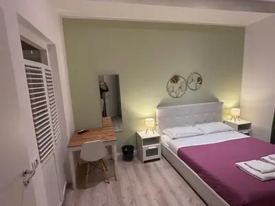 a bedroom with a bed and a desk and two mirrors at Spazio Cavour Guesthouse in Rome