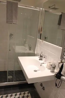 a bathroom with a white sink and a shower at Spazio Cavour Guesthouse in Rome