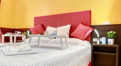 a bedroom with a bed with a red headboard at Termini Suites in Rome