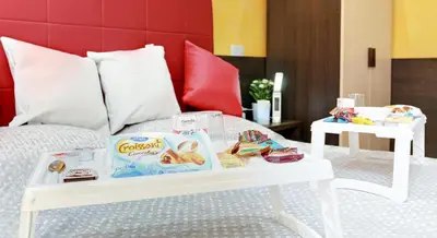 a white coffee table with food on a bed at Termini Suites in Rome