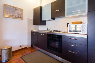 a kitchen with black cabinets and a microwave at Altieri Loft Pantheon in Rome