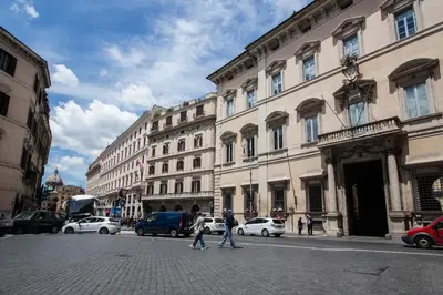two people crossing a street in a city with buildings at Altieri Loft Pantheon in Rome