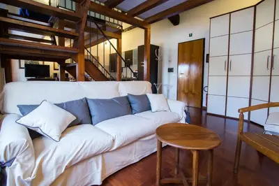 a living room with a white couch and a wooden table at Altieri Loft Pantheon in Rome
