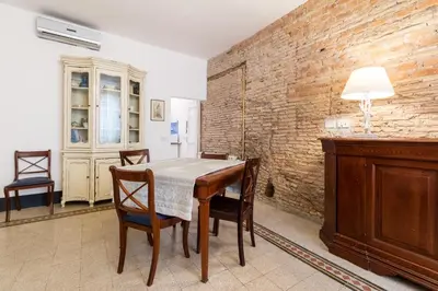 a dining room with a table and chairs and a brick wall at Tetti di Piazza Navona in Rome