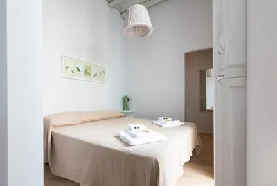 a white bedroom with a bed with two towels on it at Ideal Apartment D'Ascanio, Piazza Navona in Rome
