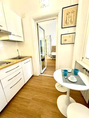 a white kitchen with a white table and a table at Angelico 90 in Rome
