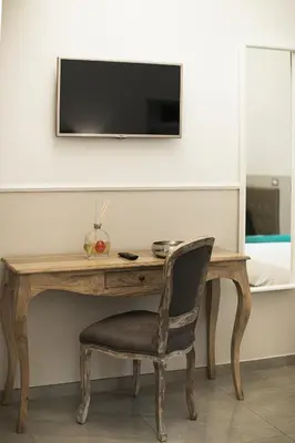a wooden desk with a chair and a television on a wall at Vaticano Luxury Guest House in Rome