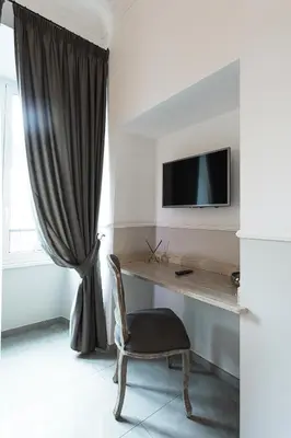 a room with a desk with a chair and a television at Vaticano Luxury Guest House in Rome