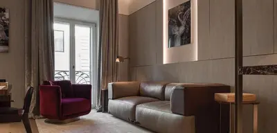 a living room with a leather couch and a chair at Fendi Private Suites - Small Luxury Hotels of the World in Rome
