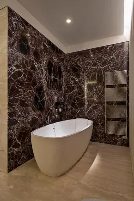 a bath tub in a bathroom with a marble wall at Fendi Private Suites - Small Luxury Hotels of the World in Rome