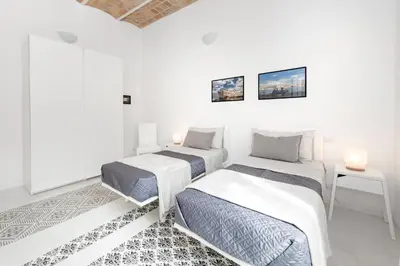 two beds in a room with white walls at Vatican White Domus in Rome