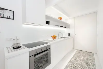 a white kitchen with a sink and a stove at Vatican White Domus in Rome