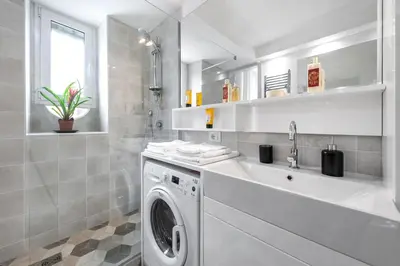 a white bathroom with a washing machine and a sink at Vatican White Domus in Rome