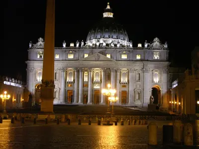 a large white building with a dome at night at Vatican White Domus in Rome