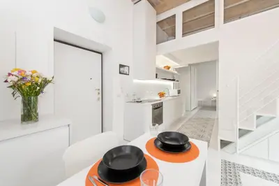 a white kitchen with two black hats on a table at Vatican White Domus in Rome