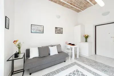 a white living room with a couch and a table at Vatican White Domus in Rome