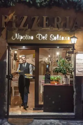 a man holding a plate of food in a store window at Casa in Monti in Rome