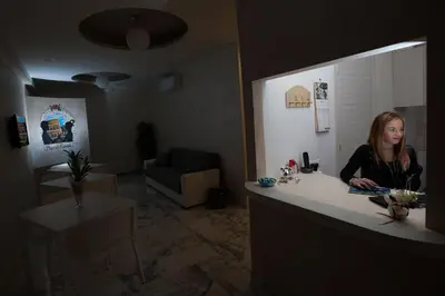 a woman sitting at a counter in a room at B&B Momenti Romani in Rome
