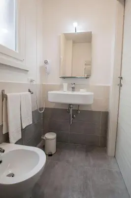 a white bathroom with a sink and a toilet at B&B Momenti Romani in Rome