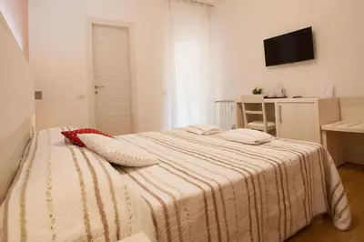 a bedroom with a bed with a striped blanket at B&B Momenti Romani in Rome