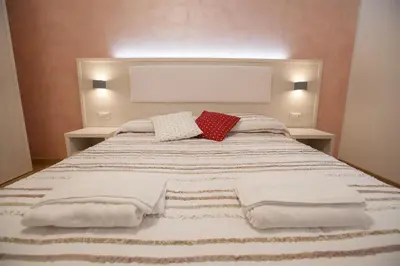 a bed with white blankets and red pillows on it at B&B Momenti Romani in Rome