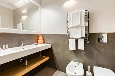 a bathroom with a sink and a toilet and a mirror at Vatican Guest House in Rome