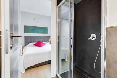 a bathroom with a glass door leading to a bedroom at Vatican Guest House in Rome
