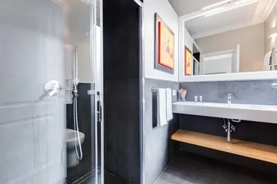 a bathroom with a shower and a sink and a mirror at Vatican Guest House in Rome
