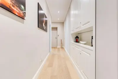 a kitchen with white cabinets and a wooden floor at Vatican Guest House in Rome