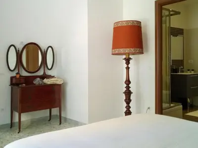 a bedroom with a bed and a lamp and two mirrors at The Pope At The Window in Rome