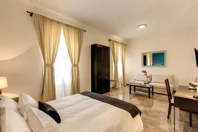 a bedroom with a bed and a table and a desk at YH SUITE 131 in Rome