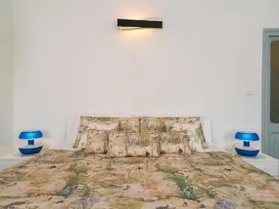 a bedroom with a large bed with blue lamps at Garibaldi Roof Garden in Rome