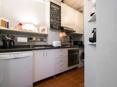 a kitchen with white cabinets and a sink and a dishwasher at Garibaldi Roof Garden in Rome