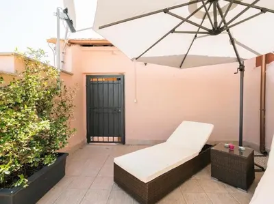 a patio with a bench and an umbrella at Garibaldi Roof Garden in Rome