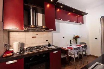 a kitchen with red cabinets and a table with chairs at Vatican Balcony in Rome