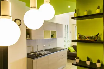 a kitchen with white and green walls and lights at The Green Corner in Rome