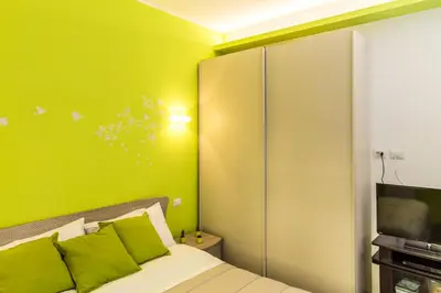 a bedroom with green walls and a bed with green pillows at The Green Corner in Rome