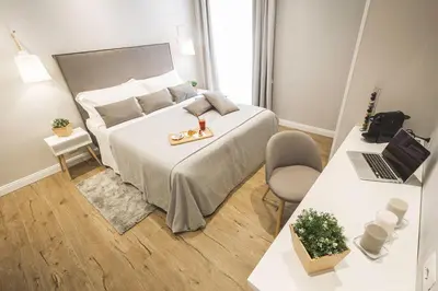 a bedroom with a bed and a desk with a laptop at Colonna Luxury Suites in Rome