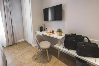a room with a desk with a chair and a bag at Colonna Luxury Suites in Rome