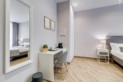 a bedroom with a desk and a bed and a mirror at Colonna Luxury Suites in Rome