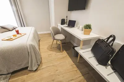 a bedroom with a bed and a desk with a laptop at Colonna Luxury Suites in Rome