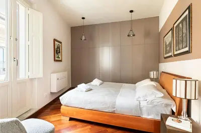 a bedroom with a white bed and a window at Trevi Charming Penthouse in Rome