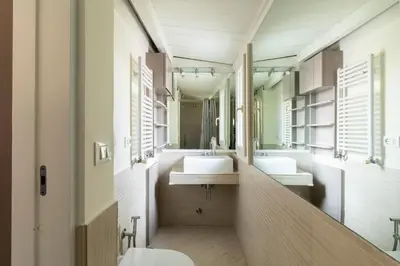 a bathroom with two sinks and two mirrors at Trevi Charming Penthouse in Rome
